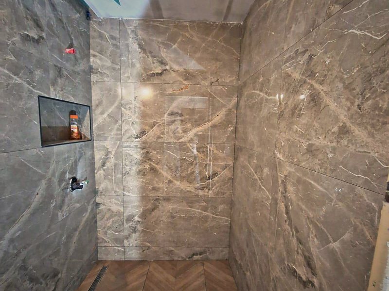 Baie finisată, placată cu marmură, cu duș walk-in